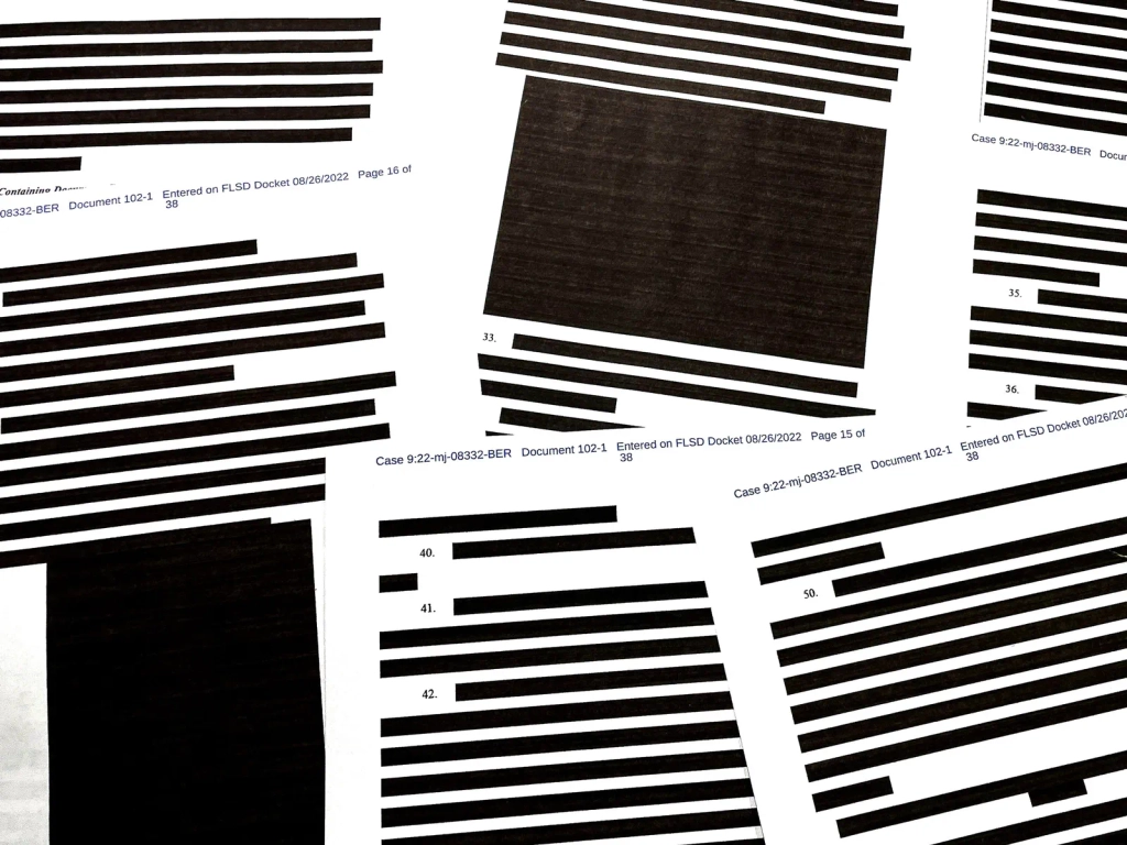 Papers sprawled out with redactions